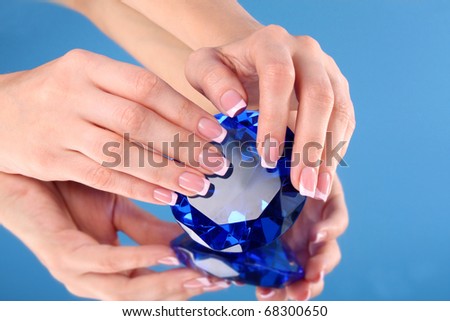 Beautiful woman hands with french manicure on blue background
