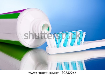 toothpaste and brush on a blue background