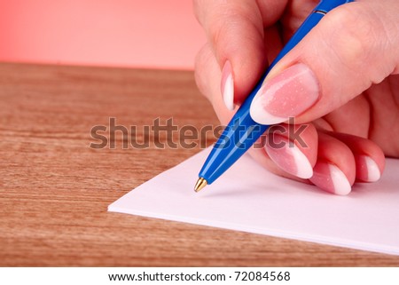 pen in hand writing on paper