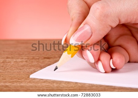 woman hand writing yellow wood pencil on paper