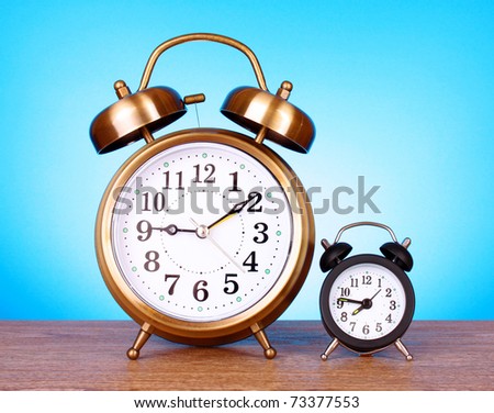 Two clocks with different time on blue background