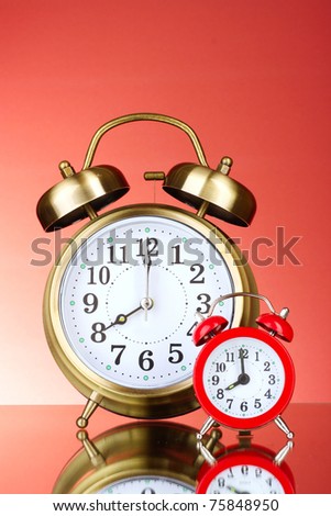Two Alarm-clocks on red background