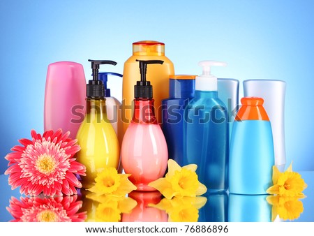 bottles of health and beauty products on blue background with reflection