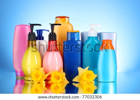 bottles of health and beauty products on blue background with reflection