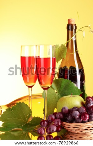 Wine and fruits on yellow background