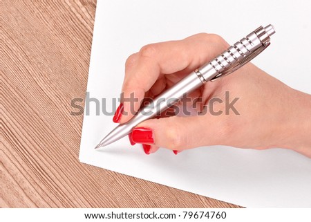 woman's hand,  pen and paper on wooden background