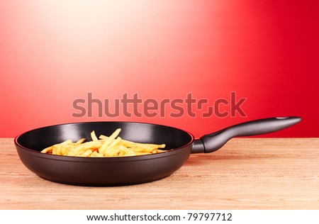 French fries in the pan on a red background