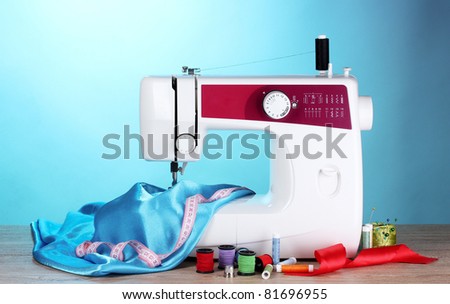 sewing machine and fabric on blue background