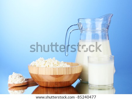 Tasty milk and cottage cheese on  blue background