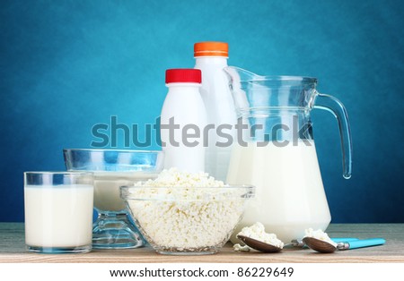 Dairy products on wooden table on blue background
