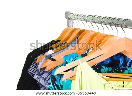 different clothes on wooden hangers on green background