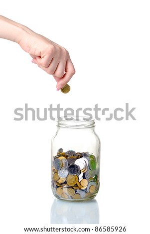Glass bank for tips with money and hand isolated on white
