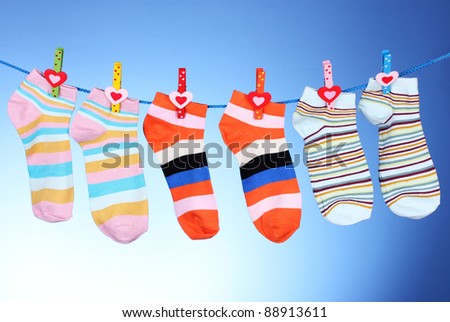 Bright striped socks on line on blue background