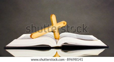 Russian bible and wooden cross on black background