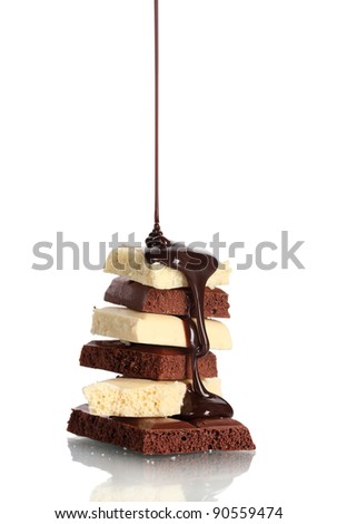 Slices of milk and white chocolate bar poured chocolate isolated on white