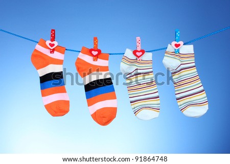 Bright striped socks on line on blue background