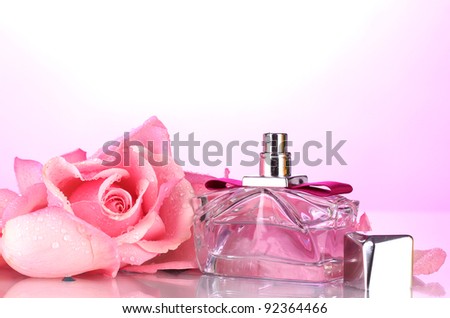 Perfume bottle and pink rose on pink