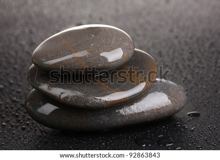 spa stones with water drops on black background