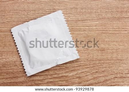 stock-photo-one-condom-on-wooden-background-93929878.jpg