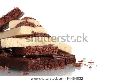 Slices of milk and white chocolate bar with chocolate shavings isolated on white