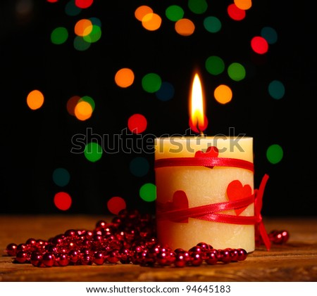 Beautiful candle on wooden table on bright background