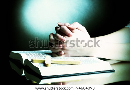 Female hands on open russian holy bible on black backround Female hands on open russian holy bible on black backround