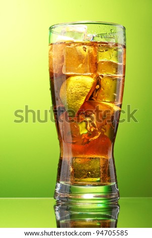 Iced tea with lemon and lime on green background