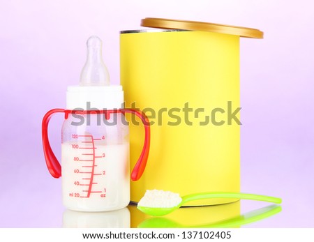 Bottle with milk and food for babies on purple background