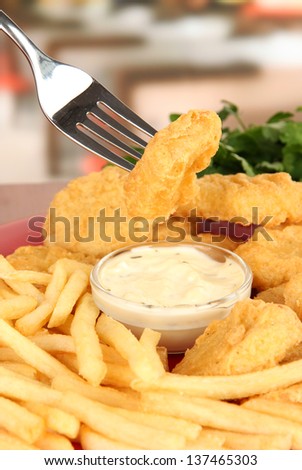 Fried chicken nuggets with french fries and sauce on table in cafe