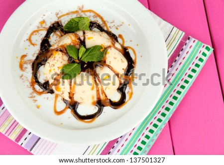 Panna Cotta with chocolate  and caramel sauce, on color wooden background
