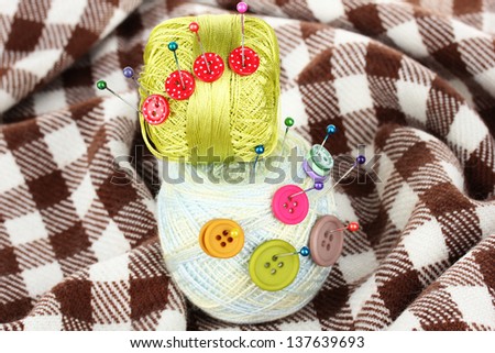 Buttons of different colors, and the two tangle thread on checked plaid