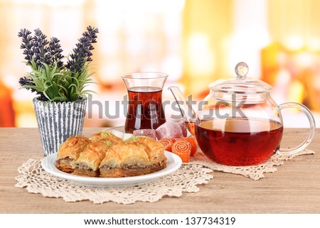 Sweet baklava on plate with tea on table in room