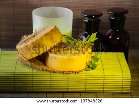 Hand made soap and ingredients for soap making on bamboo mat background
