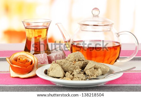 Tasty halva with tea on table in room