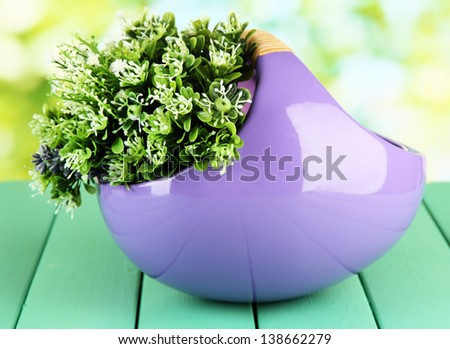 Pot with flowers on a wooden table on the nature background