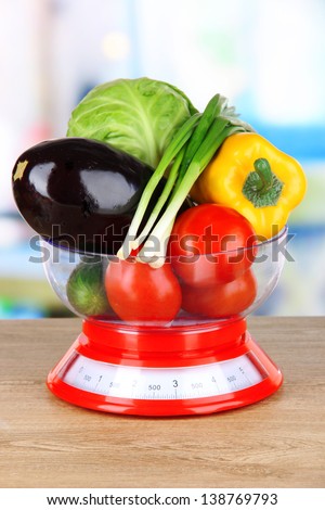 Fresh vegetables in scales on table in kitchen