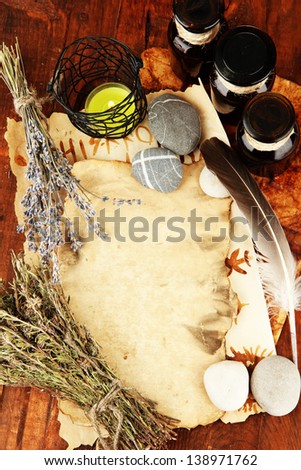 Composition with old papers, herbs, stones and bottles with symbols on wooden background