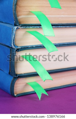 Many books with bookmarks on purple background