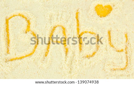 Word baby making with powdered milk on yellow background
