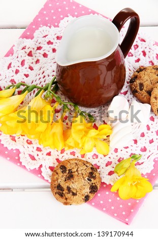 Beautiful composition of milk and cookies on wooden picnic table close-up
