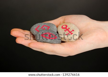 Fortune telling  with symbols on stone in hand on grey background
