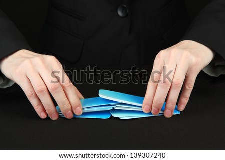 Hand with business cards. Concept: Business like poker game. Isolated on black