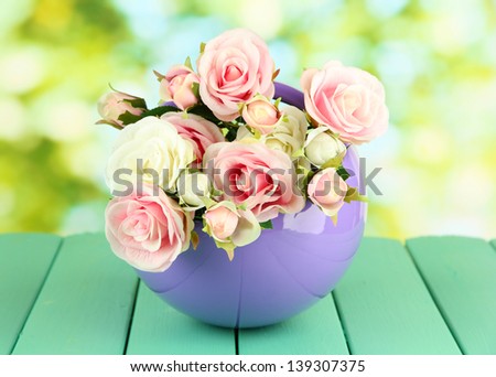 Pot with flowers on a wooden table on the nature background