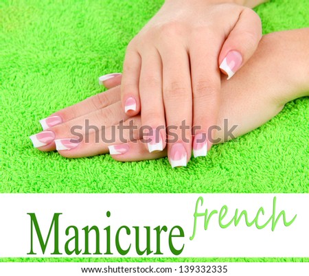 Woman hands with french manicure on green towel