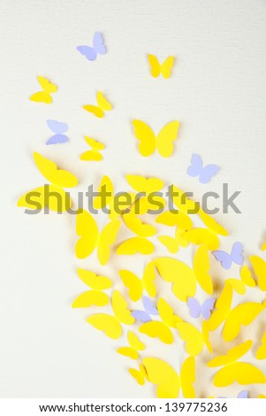 Paper yellow butterfly in form of heart on wall