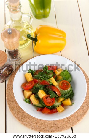 Light salad in plate on wooden table