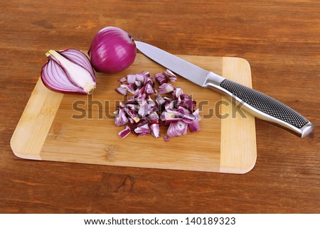 Cutting purple onion on wooden background