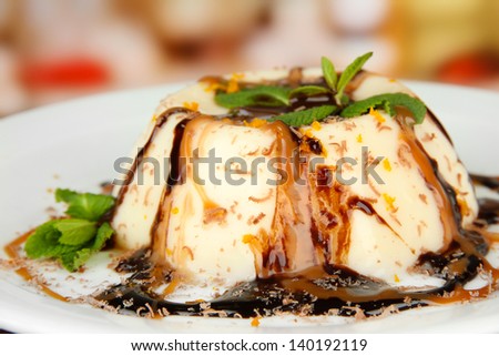 Panna Cotta with caramel and chocolate sauces, on bright background
