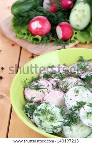 Vitamin vegetable salad in bowl on wooden table close-up