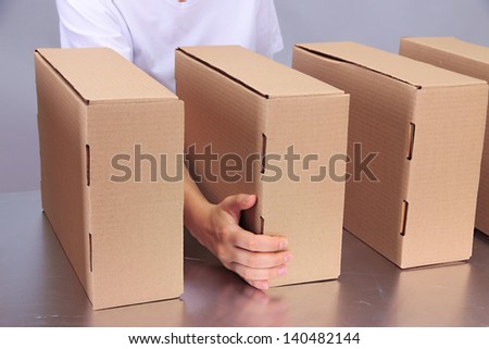 Worker working with boxes at conveyor belt, on grey background
